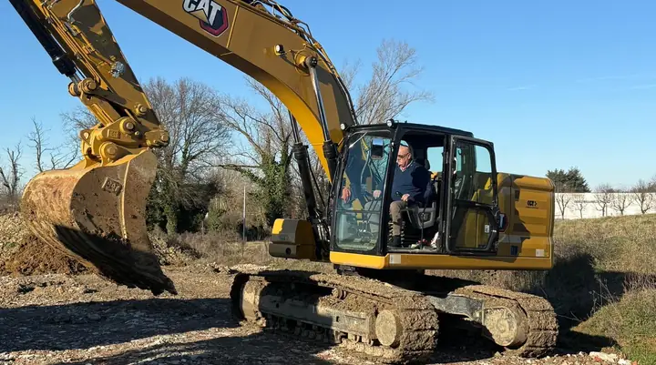 Escavatore cingolato giallo con benna in cantiere