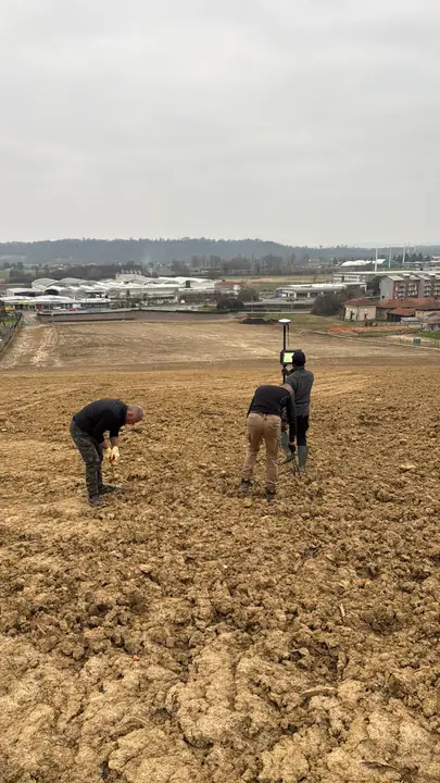 Tecnici al lavoro con strumento GPS nel campo prima dell'impianto