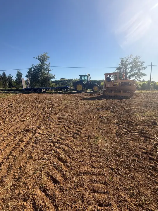 Terreno appena lavorato con un apripista sullo sfondo