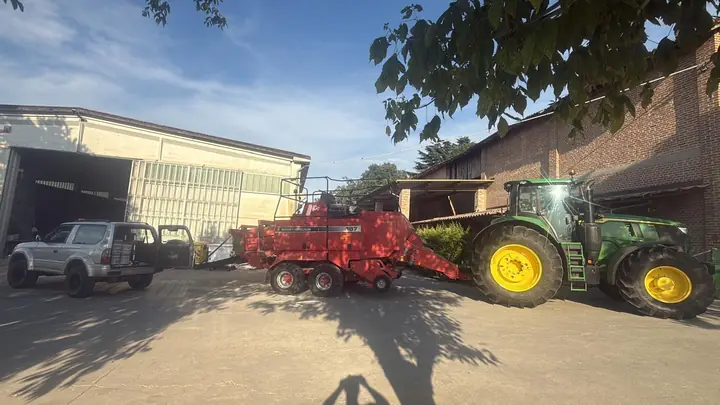 Trattore con pressa per balle nel cortile aziendale